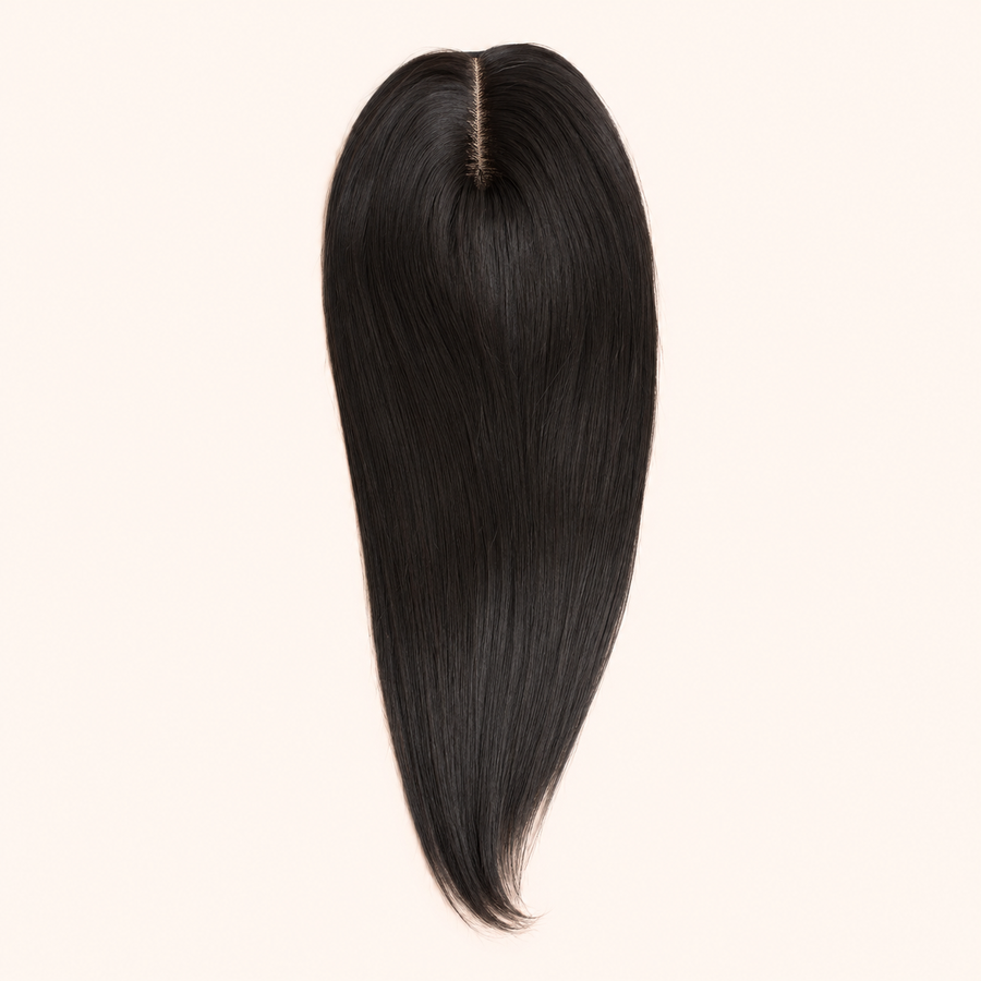 Natural-black CrownLift 20-inch mono topper with centre part on a warm ivory background